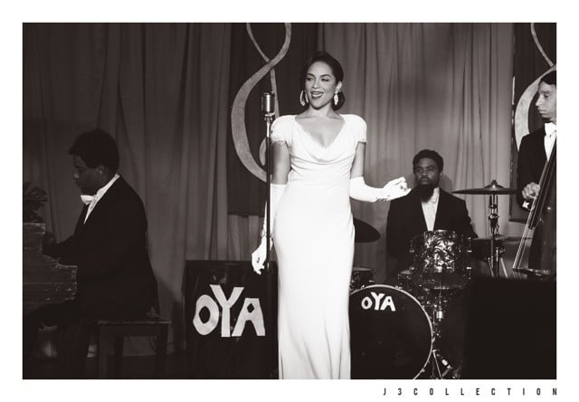 Woman in white dress holding microphone, performing jazz music.